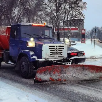 Снігоочисник ЗІЛ з плугом і розкидачем солі на засніженій вулиці Дніпра, січень 2026
