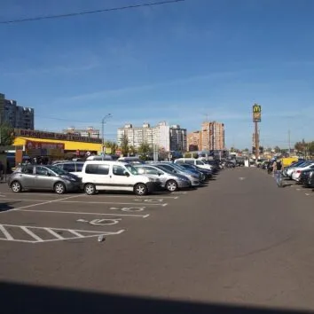 Сірі, білі й чорні авто на парковці торговельного центру в Києві